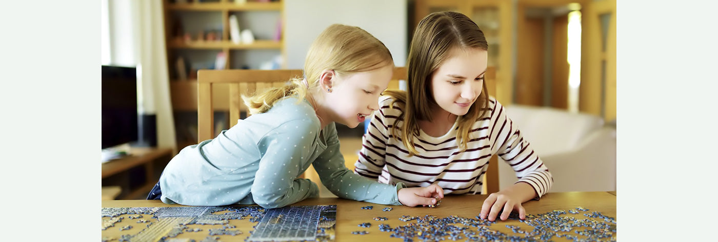 Imagen de dos niñas haciendo puzzles para el árticulo "¿Cómo elegir el puzzle perfecto para tu hijo?" del blog PuzzlesIn. 